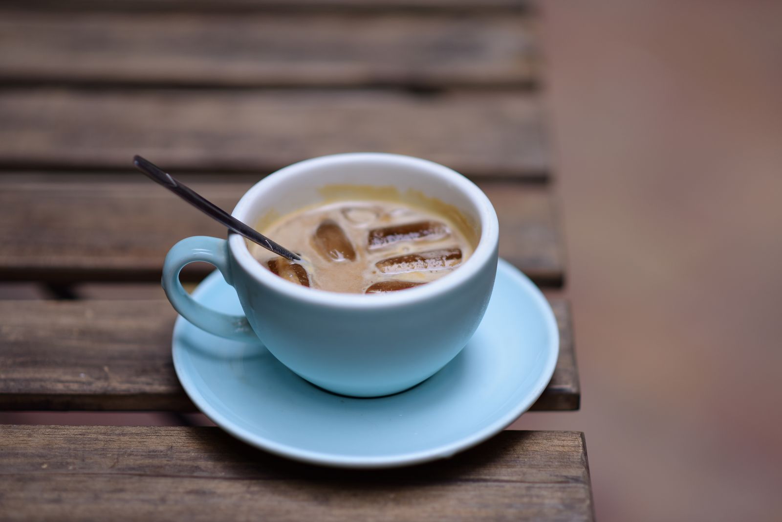Tasse Kaffee mit Löffel auf Holztisch